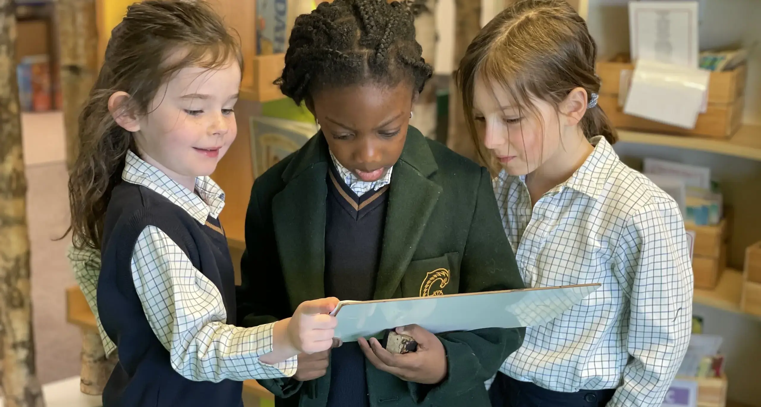 Three pupils read a book together