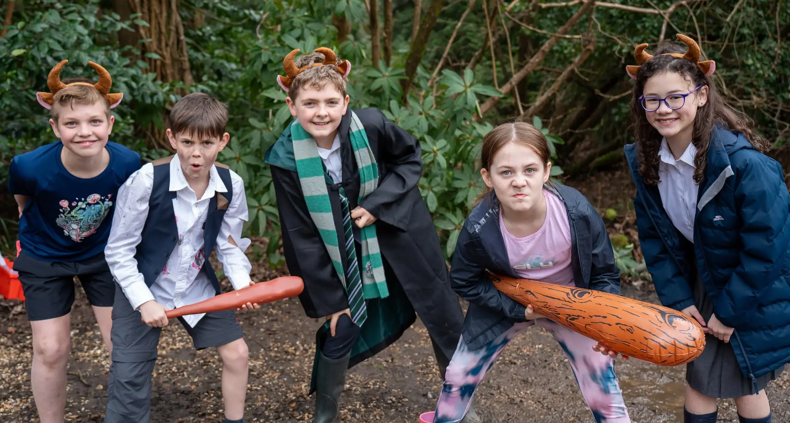 Three children in the woods with toys