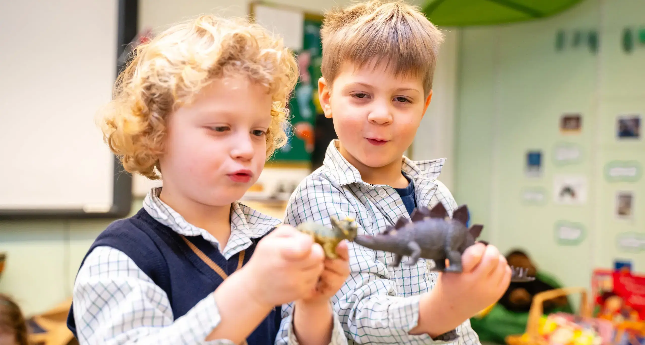 Nursery students playing with dinosaur.