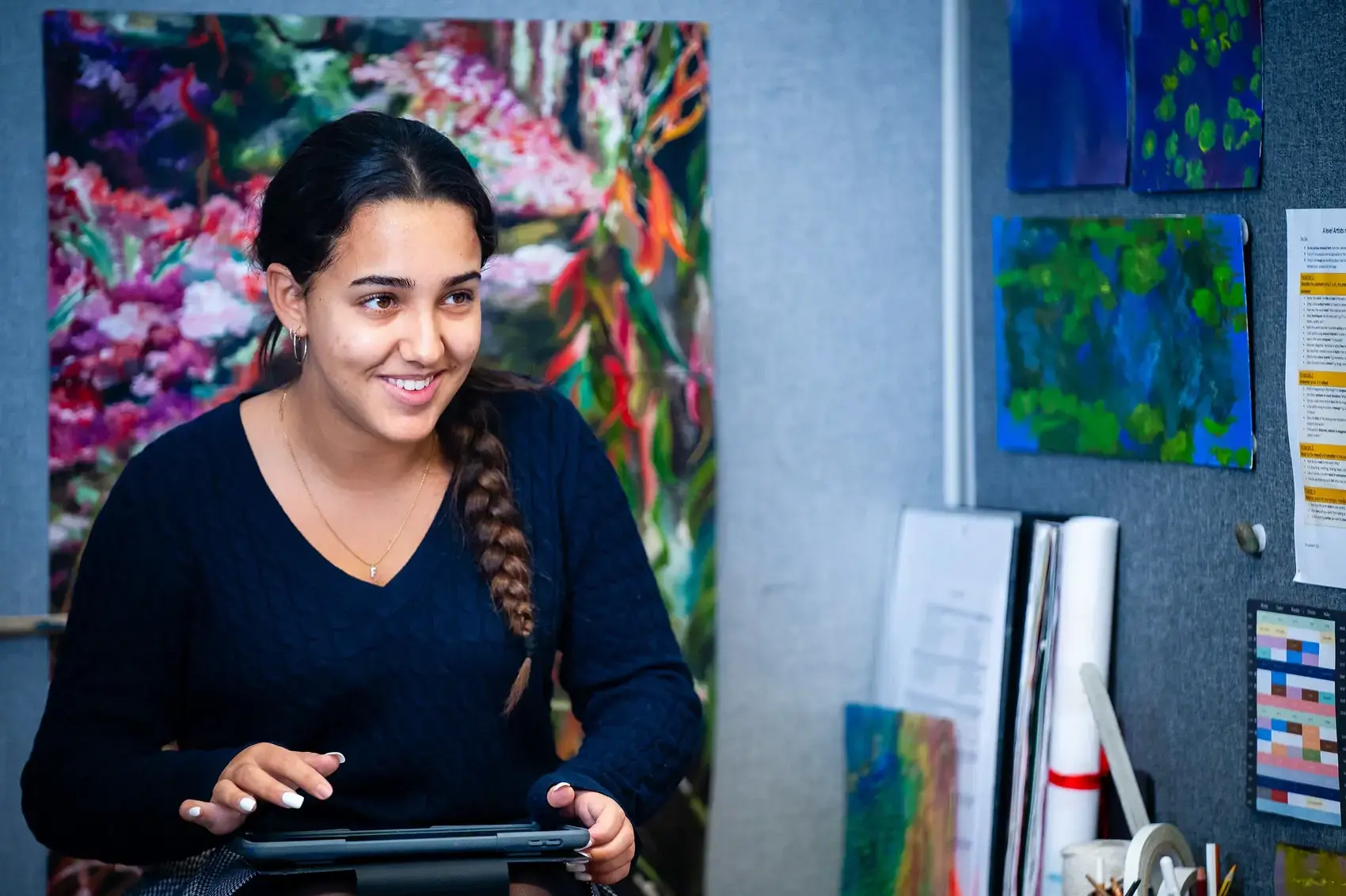 Student smiling while studying in a classroom.