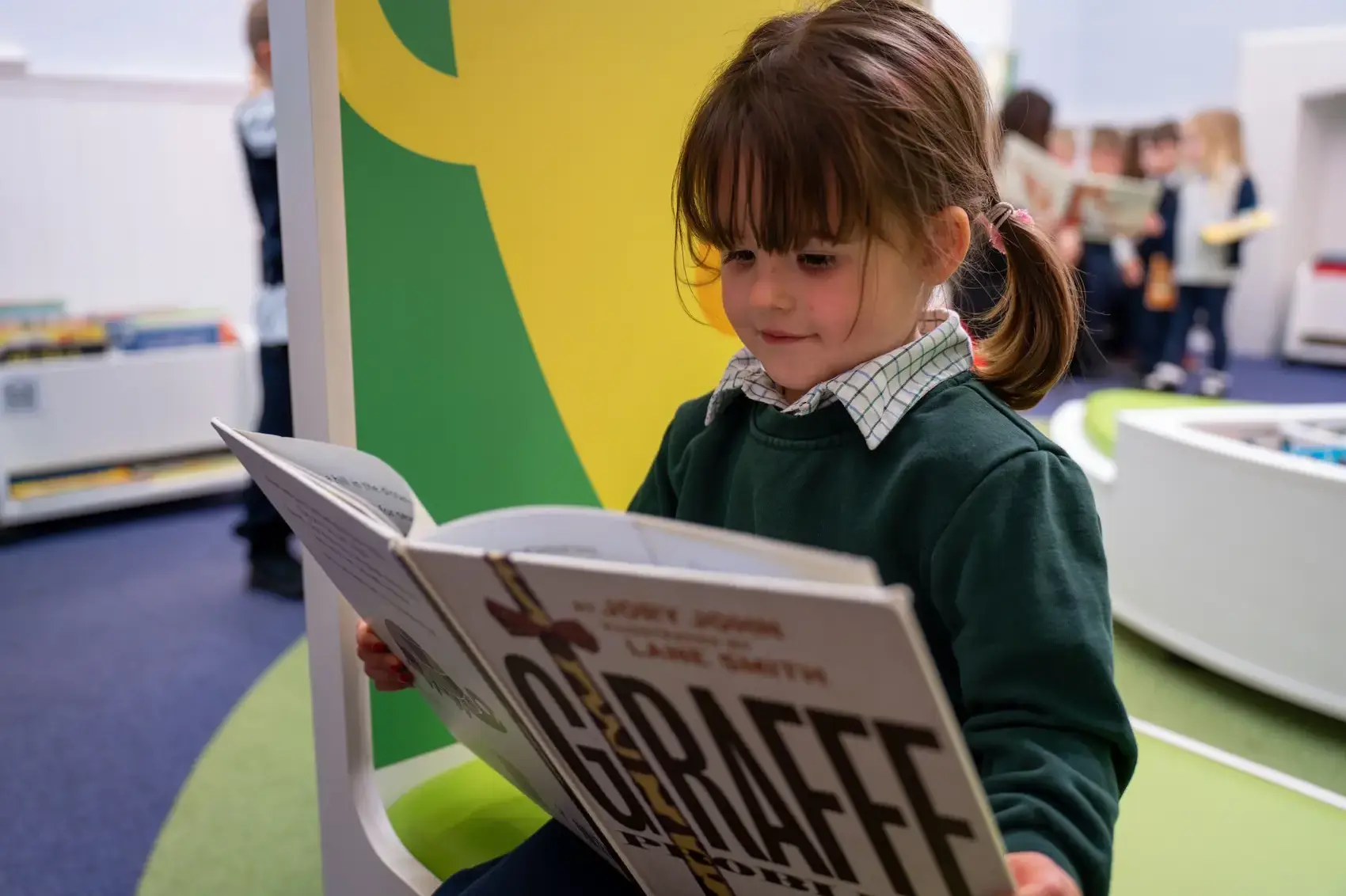 A young girl reading a book on page image